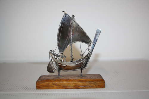 A small silver white metal boat on a stand,14cm ht x 11cm in width.