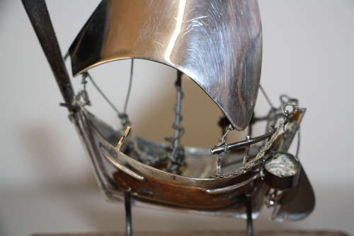 A small silver white metal boat on a stand,14cm ht x 11cm in width.