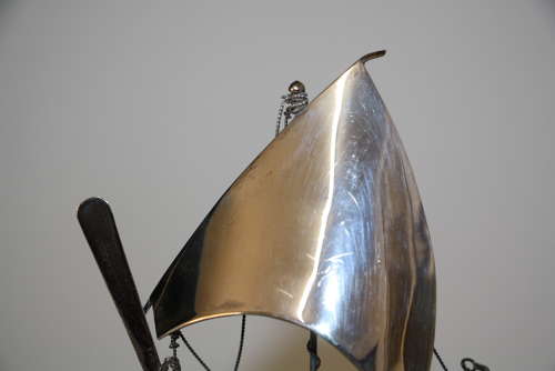 A small silver white metal boat on a stand,14cm ht x 11cm in width.