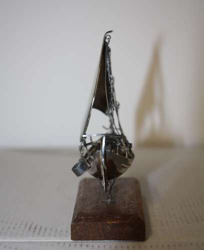 A small silver white metal boat on a stand,14cm ht x 11cm in width.